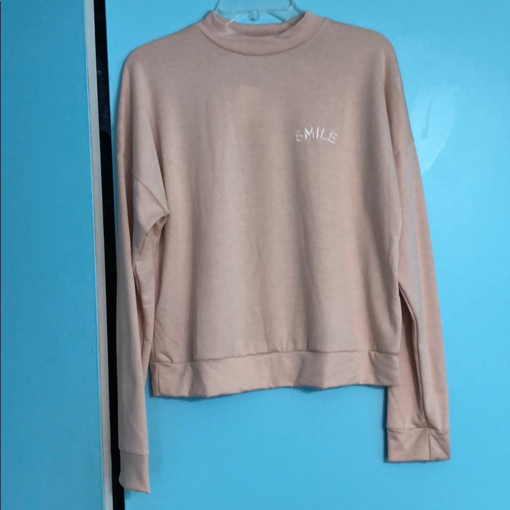 A light sweater with a smile logo